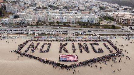 Menschen bilden am Ocean Beach in San Francisco den Schriftzug „No Kings! über einer US-Flagge bei einem „No Kings“-Protest in San Francisco. 