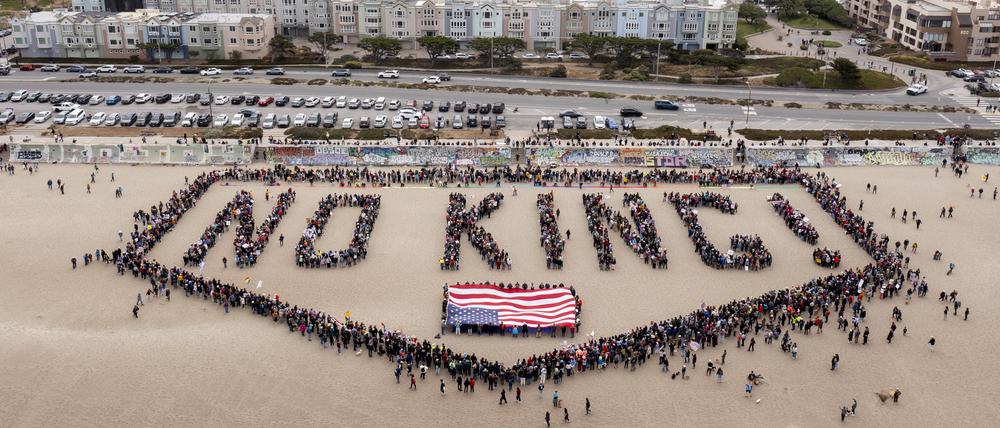 Menschen bilden am Ocean Beach in San Francisco den Schriftzug „No Kings! über einer US-Flagge bei einem „No Kings“-Protest in San Francisco. 