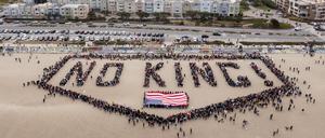 Menschen bilden am Ocean Beach in San Francisco den Schriftzug „No Kings! über einer US-Flagge bei einem „No Kings“-Protest in San Francisco. 
