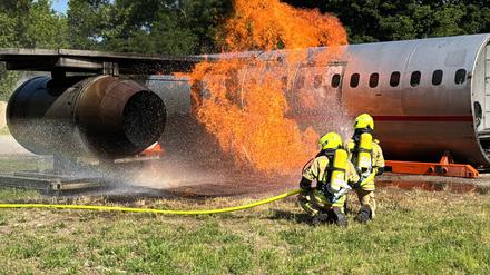 Einsatzkräfte proben das Löschen eines brennenden Flugzeugs
