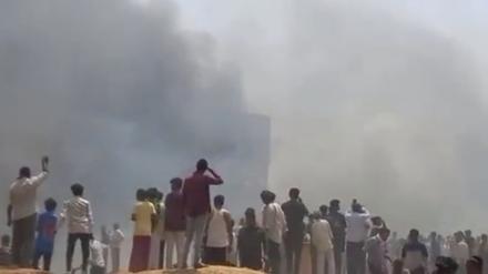 Das Videostandbild zeigt Menschen, die nach dem Flugzeugabsturz Rauch sehen.