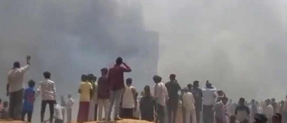 Das Videostandbild zeigt Menschen, die nach dem Flugzeugabsturz Rauch sehen.
