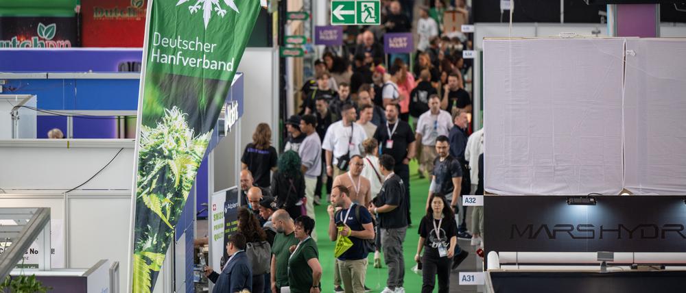 Besucher gehen durch eine Halle auf der Hanfmesse „Mary Jane“.