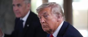 US-Präsident Donald Trump hört einer Frage eines Reporters zu, während er neben dem kanadischen Premierminister Mark Carney sitzt.