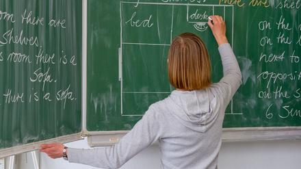 Eine Englisch-Lehrerin schreibt in einer Grundschule an die Tafel (Symbolbild).