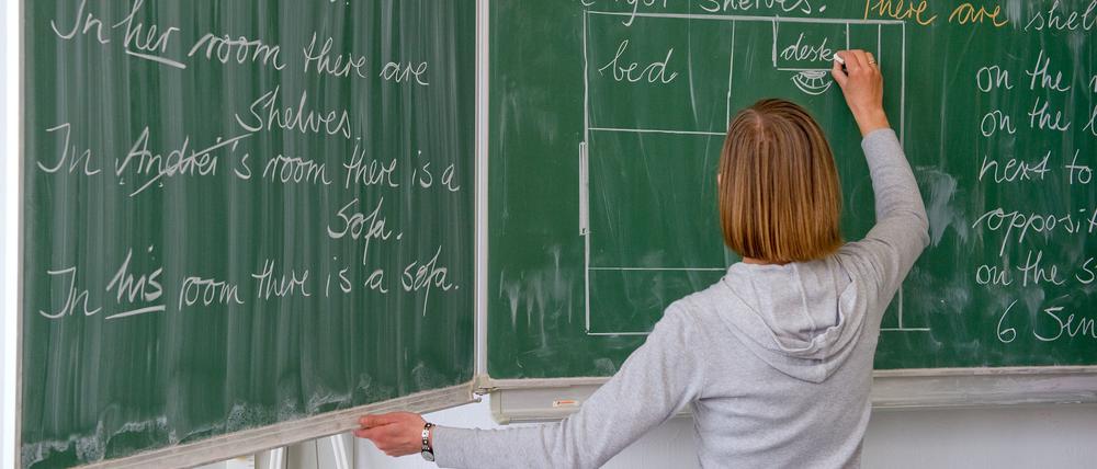 Eine Englisch-Lehrerin schreibt in einer Grundschule an die Tafel (Symbolbild).