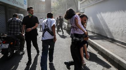 Menschen rennen am Sonntag nach einem israelischen Luftangriff durch die Straßen Teherans.