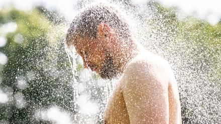 13.06.2025, Nordrhein-Westfalen, Telgte: In einem Waldfreibad steht ein Mann unter einer Dusche.