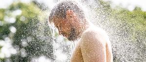 13.06.2025, Nordrhein-Westfalen, Telgte: In einem Waldfreibad steht ein Mann unter einer Dusche.
