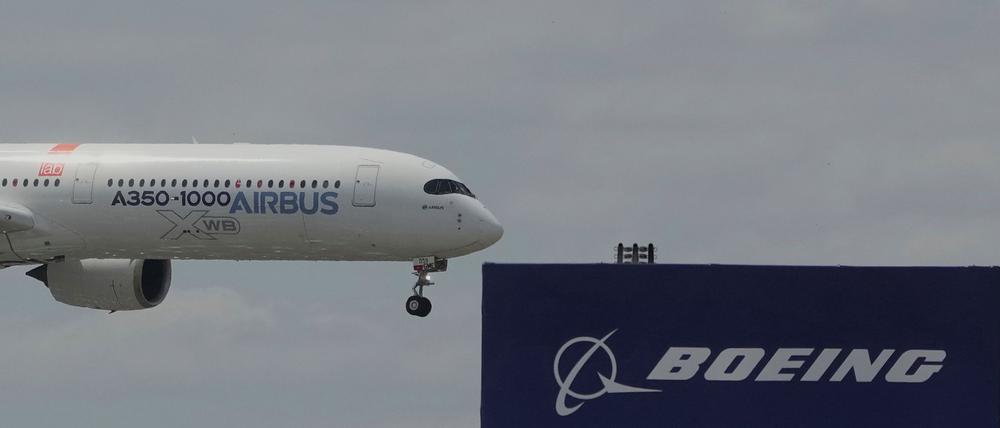 Die zwei großen Konkurrenten: Ein Airbus fliegt bei einer Vorführung auf der Luftfahrtmesse Salon du Bourget an einem Logo von Boeing vorbei.