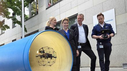 Wirtschaftssenatorin Franziska Giffey und die Vorstände der Berliner Wasserbetriebe, Kerstin Oster und Frank Bruckmann, bei der Vorführung einer Drohne zur Inspektion von Rohren.