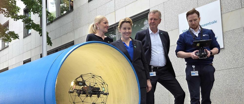 Wirtschaftssenatorin Franziska Giffey und die Vorstände der Berliner Wasserbetriebe, Kerstin Oster und Frank Bruckmann, bei der Vorführung einer Drohne zur Inspektion von Rohren.
