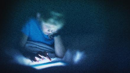 Ein Kind sitzt in diesem bearbeiteten Foto vor einem Computer (Symbolbild)