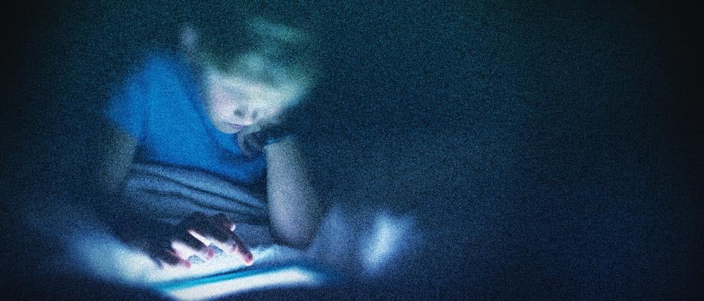 Ein Kind sitzt in diesem bearbeiteten Foto vor einem Computer (Symbolbild)