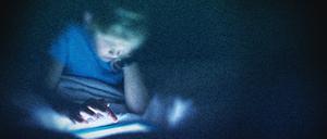 Ein Kind sitzt in diesem bearbeiteten Foto vor einem Computer (Symbolbild)