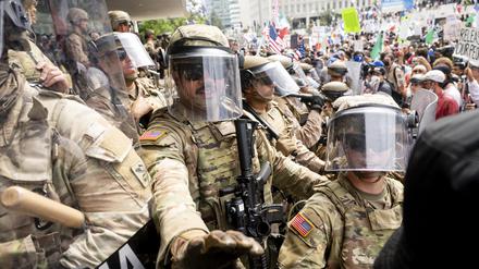 Die kalifornische Nationalgarde und Marineinfanteristen drängen Demonstranten zurück während einer Demonstration vor dem Bundesgebäude.