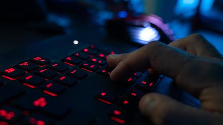 Ein Mann sitzt am Rechner und tippt auf einer Tastatur (Symbolbild).