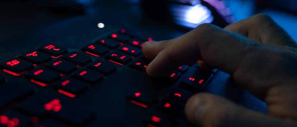Ein Mann sitzt am Rechner und tippt auf einer Tastatur (Symbolbild).