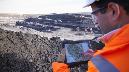 Ein Archäologe analysiert mit einem Tablet die Oberfläche einer Kohlemine.