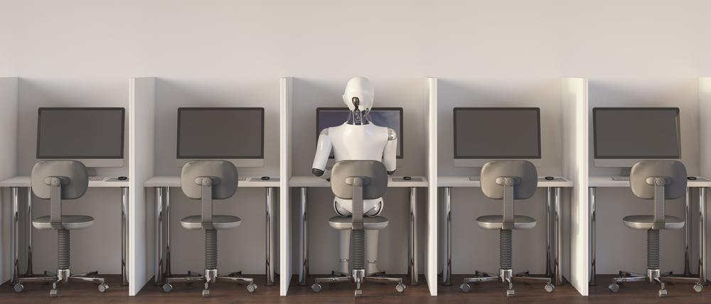 Ein Roboter sitzt an einem Arbeitsplatz (Symbolbild).
