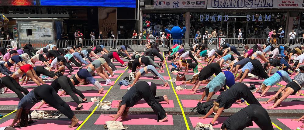 Trotz Hitzewelle versammeln sich Hunderte für Yoga auf dem Times Square.