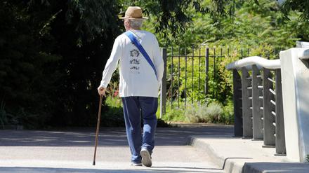 Ein älterer Mann ist bei einem Spaziergang zu sehen. 