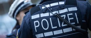 Eine Polizistin (l) und ein Polizist gehen eine Straße entlang