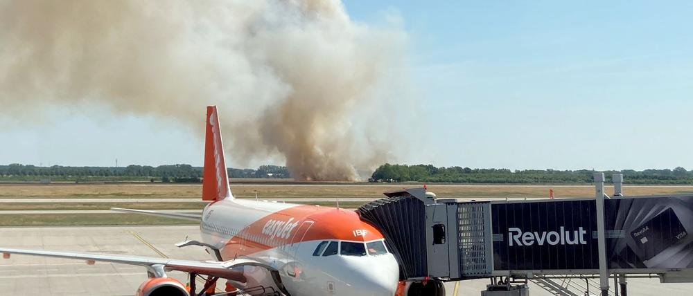 Ein Brand auf einem Getreidefeld ganz in der Nähe des Flughafens BER erzeugt auch bei Fluggästen Aufmerksamkeit. 