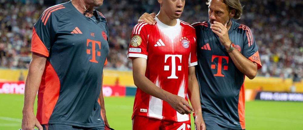 Beim Sieg gegen Boca Juniors musste Jamal Musiala (M), begleitet von Teamarzt und Physiotherapeut, angeschlagen vom Platz.