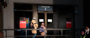 Menschen gehen an einem Streik-Schild am Eingang ins Charité-Gebäude vorbei, während sich Beschäftigte der Charité Facility Management (CFM) zu einem unbefristeten Streik vor dem Charité-Gebäude versammeln.