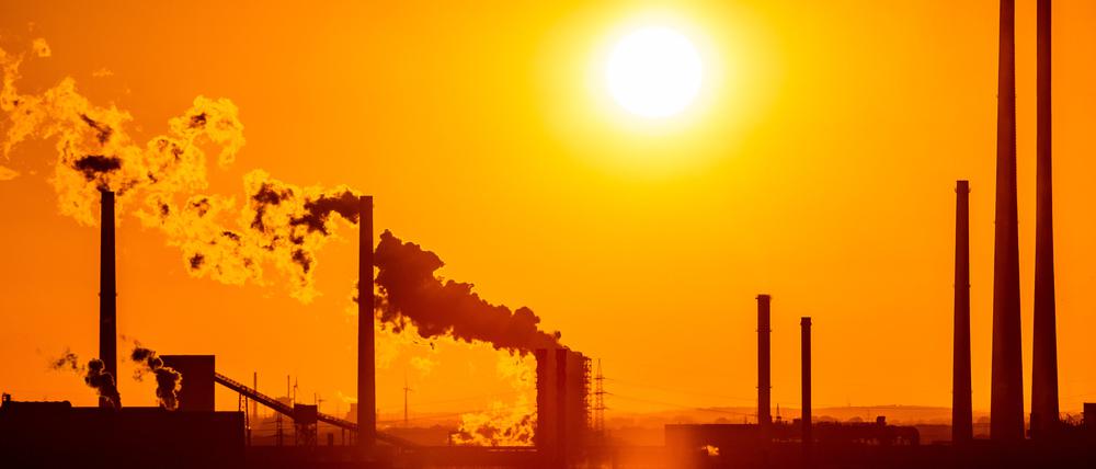 Die Sonne geht in Duisburg hinter Schornsteinen unter. (Archivbild)