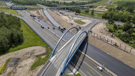 Autos und Lkw rollen über die neue A72 und die fertiggestellte Anschlussstelle Zwenkau, während im Hintergrund die Fahrbahn Richtung Chemnitz asphaltiert wird.