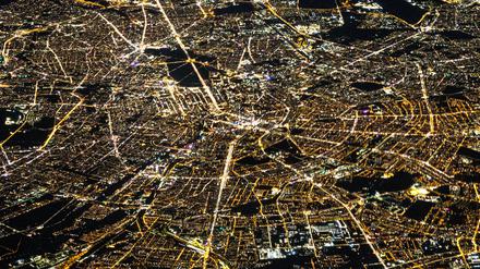 Auf diesem Luftbild von Berlin, aufgenommen aus einem Flugzeugfenster, lässt sich anhand der Lichtfarben auch heute noch die ehemalige Teilung der Stadt zu DDR-Zeiten erahnen. Das ehemalige Ostberlin leuchtet in wärmeren Gelbtönen, das ehemalige Westberlin dagegen in kühlem Weiß.