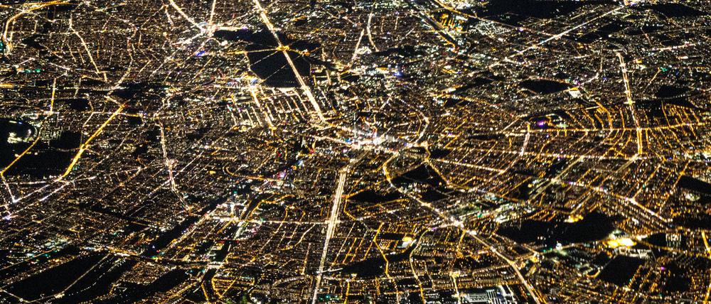 Auf diesem Luftbild von Berlin, aufgenommen aus einem Flugzeugfenster, lässt sich anhand der Lichtfarben auch heute noch die ehemalige Teilung der Stadt zu DDR-Zeiten erahnen. Das ehemalige Ostberlin leuchtet in wärmeren Gelbtönen, das ehemalige Westberlin dagegen in kühlem Weiß.
