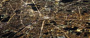 Auf diesem Luftbild von Berlin, aufgenommen aus einem Flugzeugfenster, lässt sich anhand der Lichtfarben auch heute noch die ehemalige Teilung der Stadt zu DDR-Zeiten erahnen. Das ehemalige Ostberlin leuchtet in wärmeren Gelbtönen, das ehemalige Westberlin dagegen in kühlem Weiß.