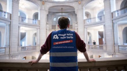 Ein Sprecher der Initiative «Volksentscheid Berlin autofrei» steht vor der Entscheidungsverkündung des Verfassungsgerichtshofs zur Zulässigkeit der Initiative «Volksentscheid Berlin autofrei» mit einer Weste mit der Aufschrift ·weniger autos mehr berlin· im Gerichtsgebäude. 
