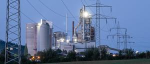 Strommasten stehen im Morgenlicht vor einem Zementwerk: Firmen mit hohem Stromverbrauch sollen staatliche Subventionen erhalten dürfen.