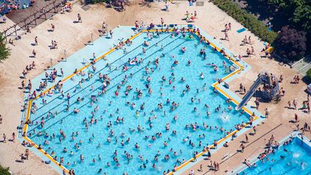 Kinder und Erwachsene baden und sonnen sich im Sommerbad Mariendorf. (Luftaufnahme). +++ dpa-Bildfunk +++