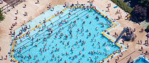 Kinder und Erwachsene baden und sonnen sich im Sommerbad Mariendorf. (Luftaufnahme).