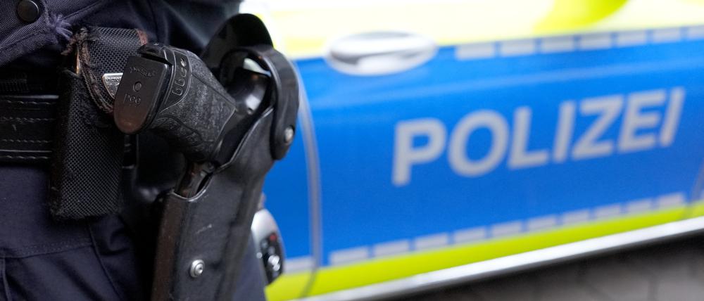 Ein Polizist steht vor einem Einsatzfahrzeug der Polizei. (Symbolbild)