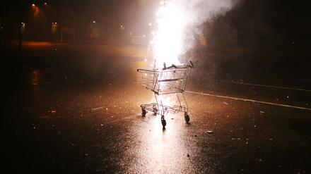 Ein Einkaufswagen mit brennendem Feuerwerk.