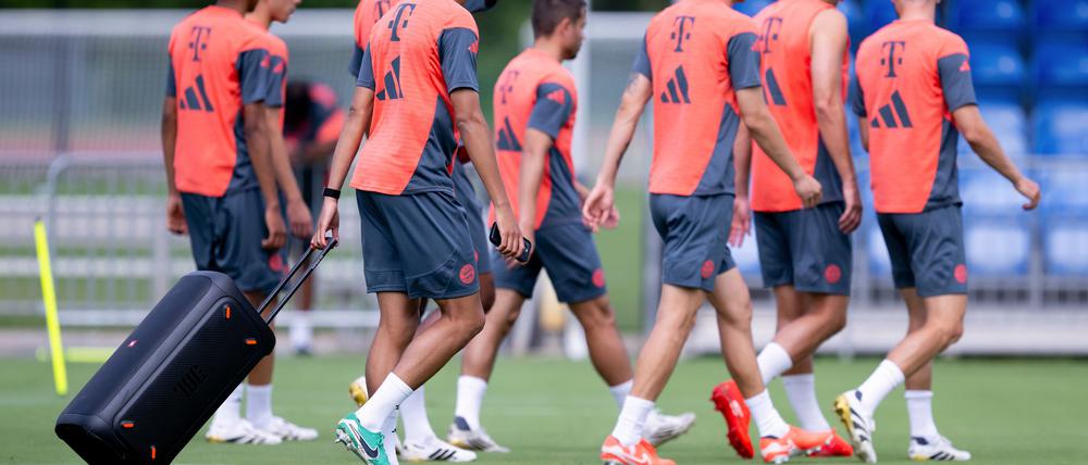 Jamal Musiala zieht beim Bayern-Training eine Musikbox auf den Platz.