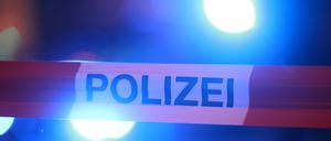 Blaulichter leuchten hinter einem Absperrband der Polizei. 