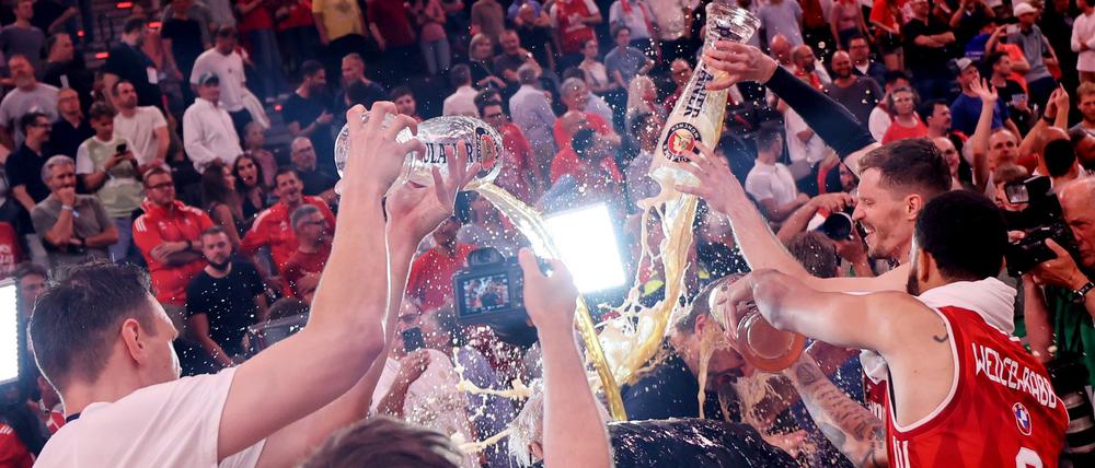 Die Bayern-Basketballer überschütten Coach Herbert mit Bier.