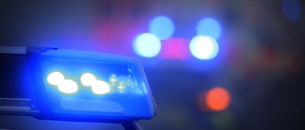 Ein Polizeiauto mit eingeschaltetem Blaulicht steht an einer Unfallstelle. (Symbolbild) 
