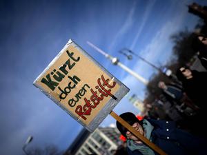 Demonstrierende protestieren gegen Kürzungen in Sozial - und Kultureinrichtungen.