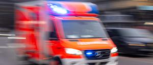 Ein Rettungswagen der Feuerwehr fährt mit Blaulicht zum Einsatz (Symbolbild)
