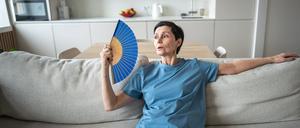 Überhitzte reife Frau sitzt zu Hause auf der Couch und wedelt mit einem Papierfächer, um sich abzukühlen, leidet unter Verstopfung Überhitzte reife Frau sitzt zu Hause auf der Couch und wedelt mit einem Papierfächer, um sich abzukühlen, leidet unter Verstopfung LicenseRF ,model released, Symbolfoto Copyright: xZoonar.com/DmitriixMarchenkox 23508060 ,model released, Symbolfoto ,property released