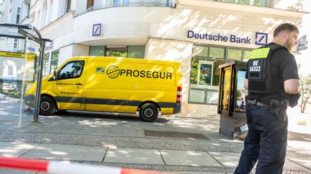 Polizisten stehen am Kurfürstendamm an einem Geldtransporter. Maskierte hatten zuvor einen Überfall begangen. Auf der Flucht sollen sie auf Polizisten geschossen haben.