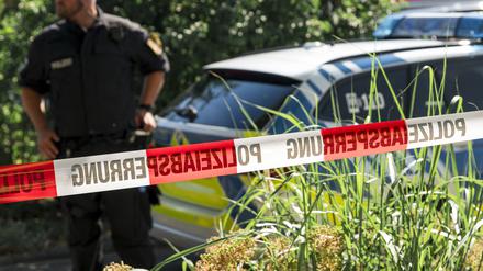 01.07.2025, Bayern, Mellrichstadt: Ein Polizist steht neben einem Polizeiauto.